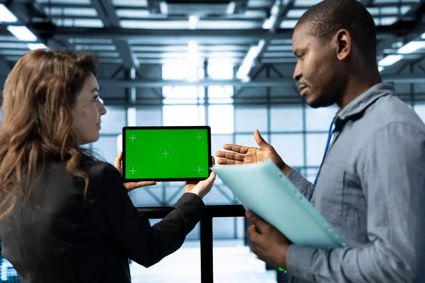 Администраторы в дата-центре, используя макет планшета, проверяют состояние инфраструктуры.