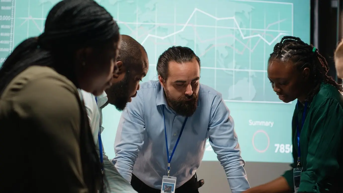 Разнообразные коллеги присутствуют на деловой встрече в нерабочее время для анализа файлов.